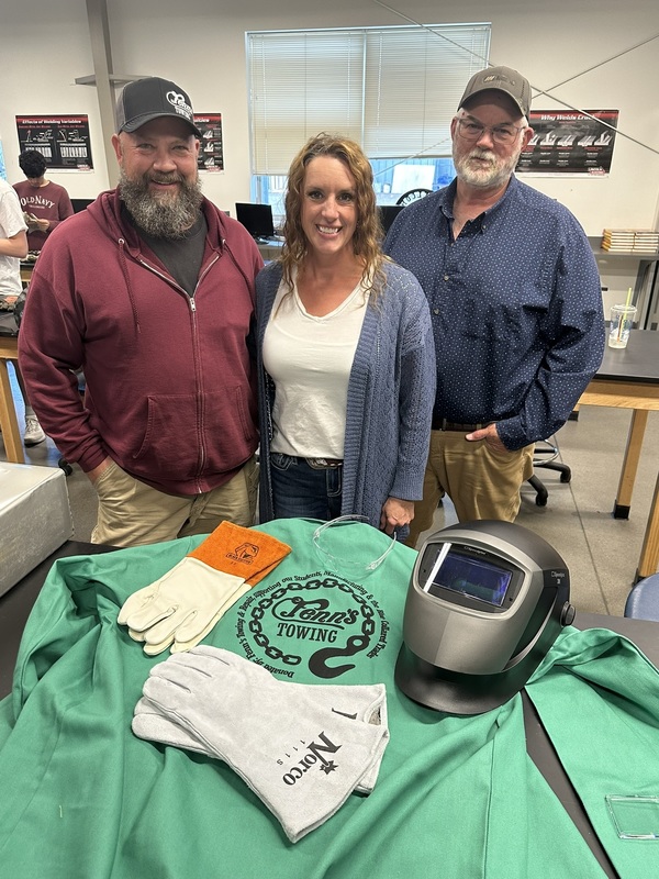 The owners of Fenns Towling behind a display of the donated items
