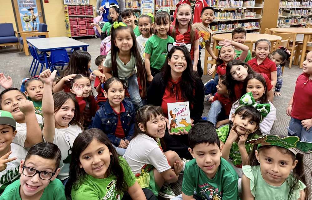 Woman holding a book surrounded by children