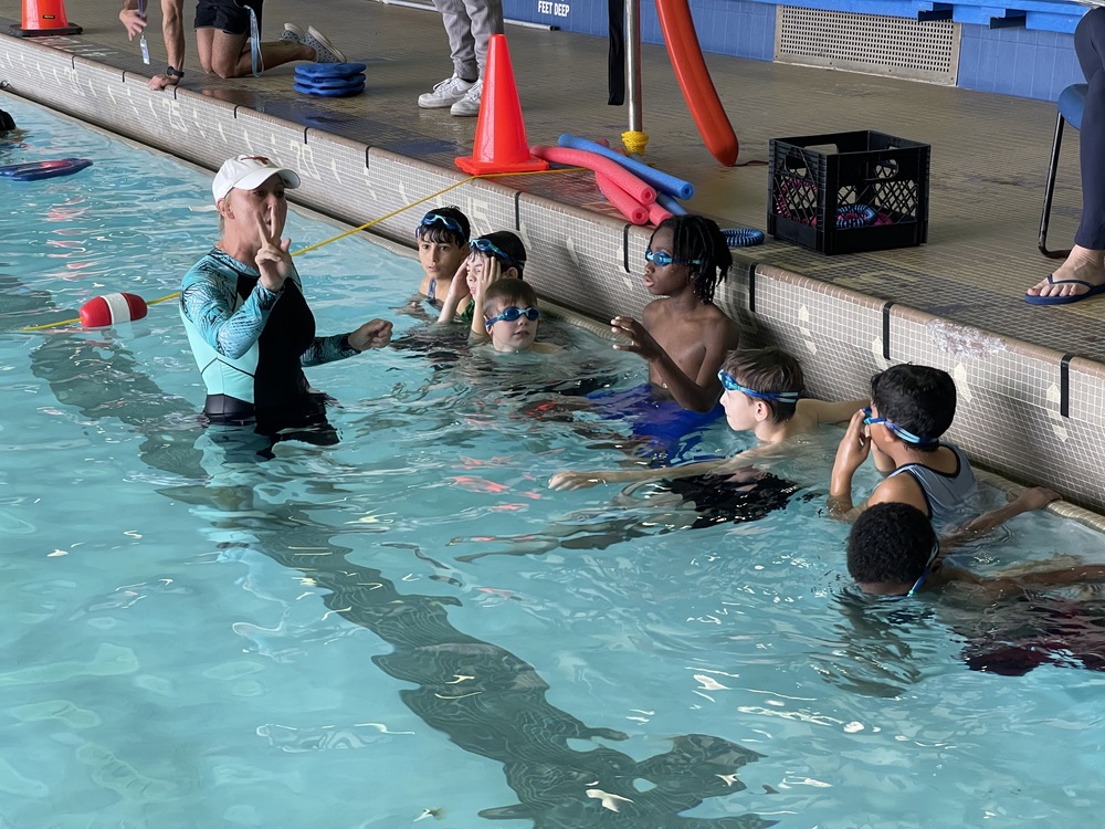 Students swim in the pool.