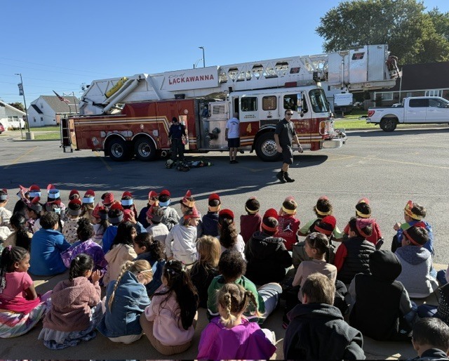kids sitting watching demonstration by fire truck