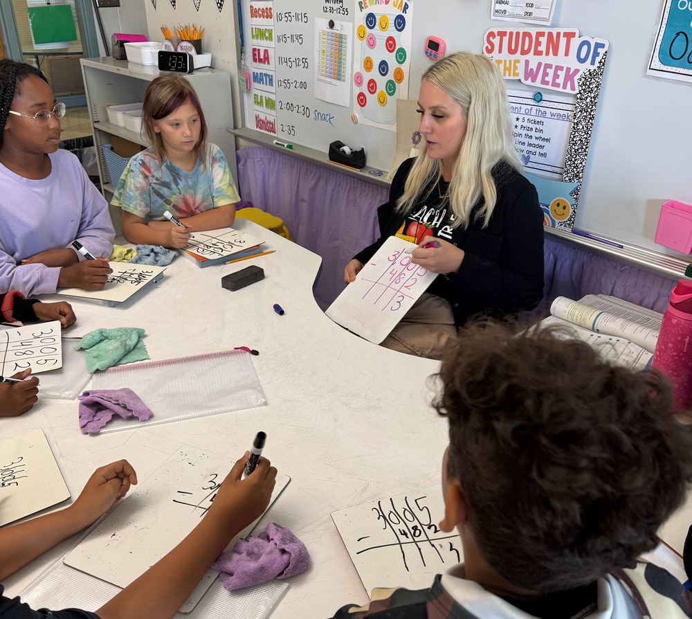 Teacher works with students on math