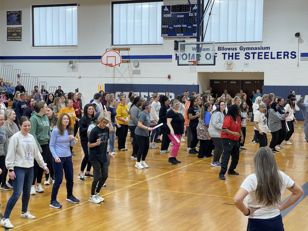 Teachers dance in the gym.