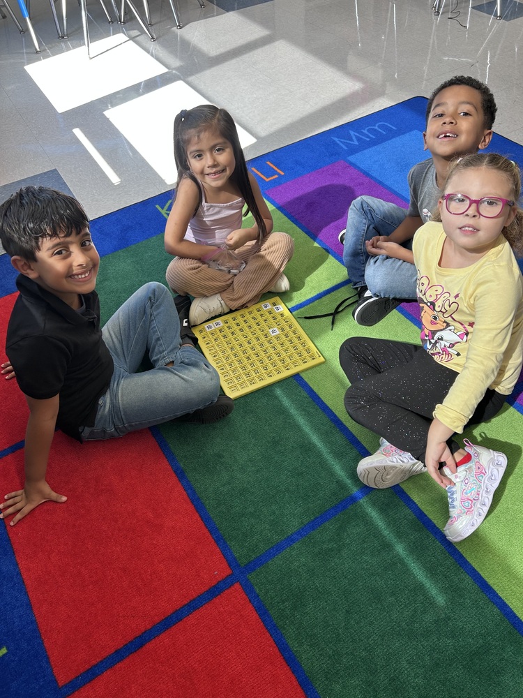 Students smile for the camera while working on visual math problems