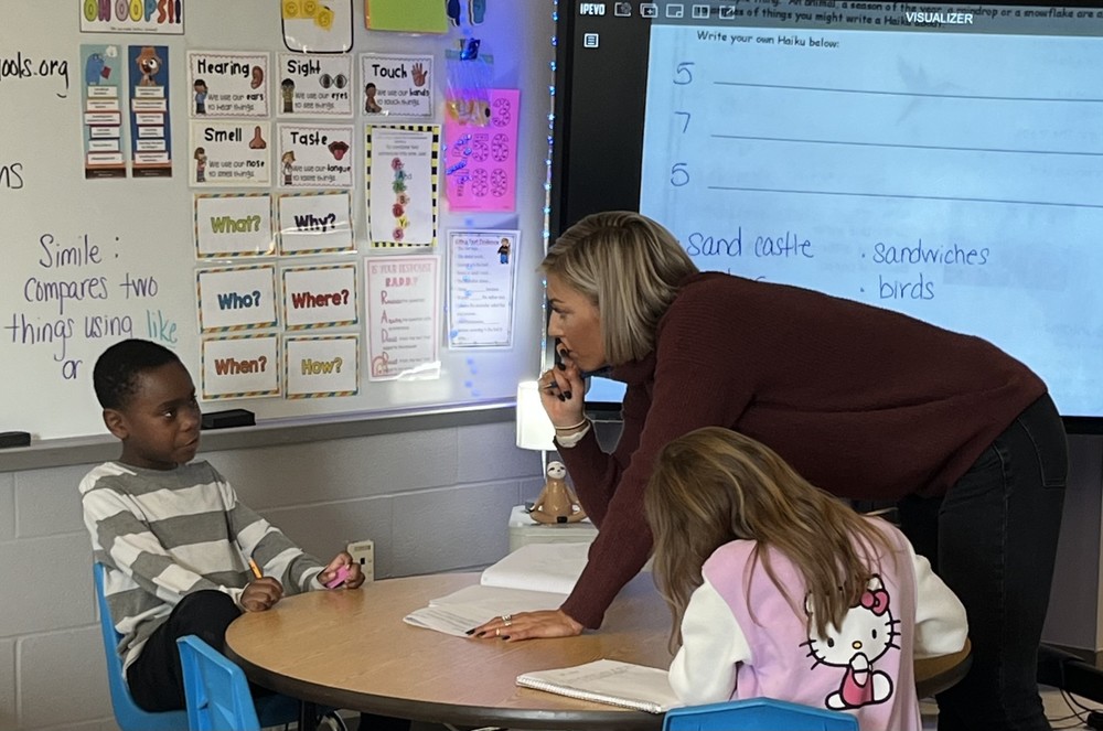 teacher working with student at table