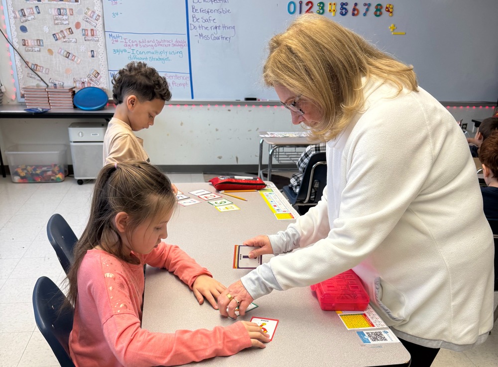 Teacher works with students in the classroom.