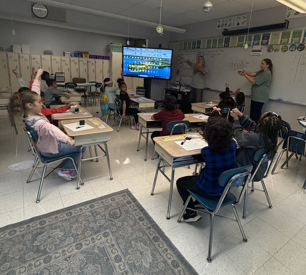 Children in a classroom paying attention to the teachers.