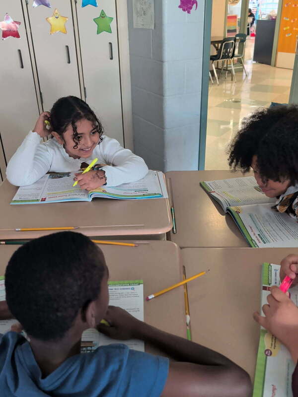 students work on workbooks at their desks