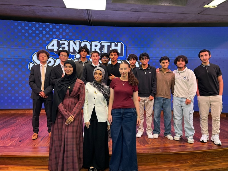 students pose in front of 43 north sign