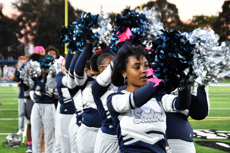 cheerleaders line up and shake pompoms in the air
