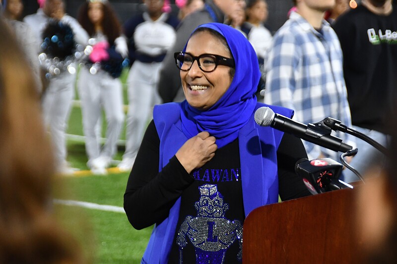 superintendent holds hand to heart and smiles at podium