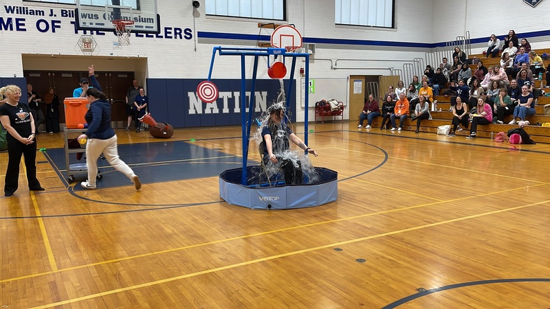 Ms. Bender gets water dumped on her in the dunk tank.