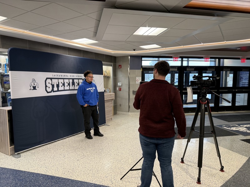 Jossiah stands in front of the news camera.
