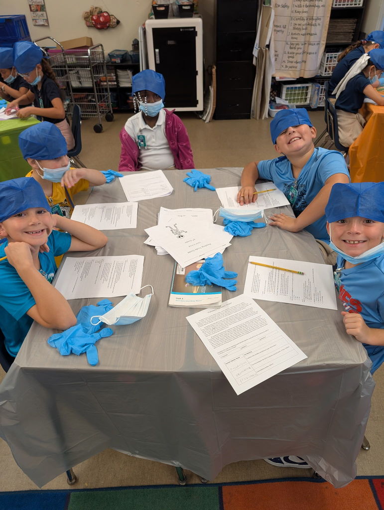 Students looking at camera while doing work. 