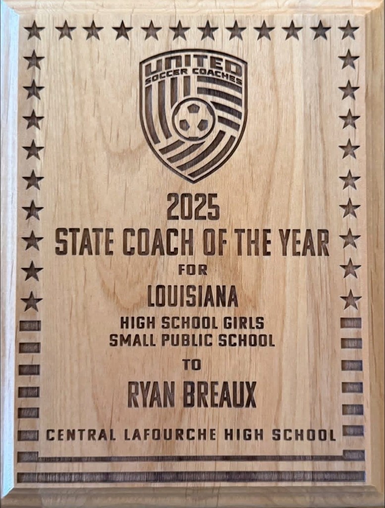 A wooden plaque engraved with 2025 State Coach of the Year for Louisiana, presented to Ryan Breaux of Central Lafourche High School.