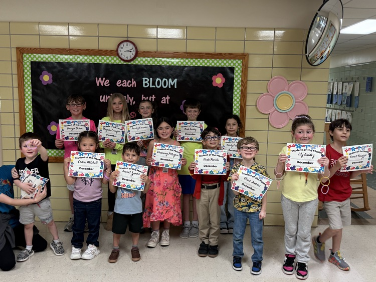 Students standing with certificates to honor student of the month nominations  