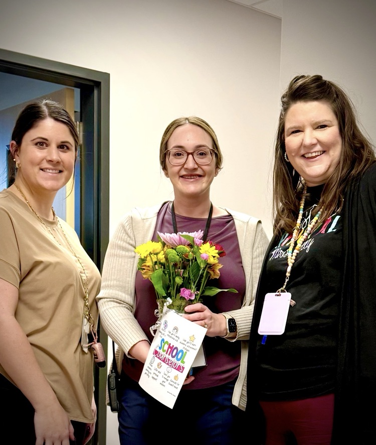 Image with our instructional coach, counselor, and assistant principal. the counselor is holding flowers for national counselor week.
