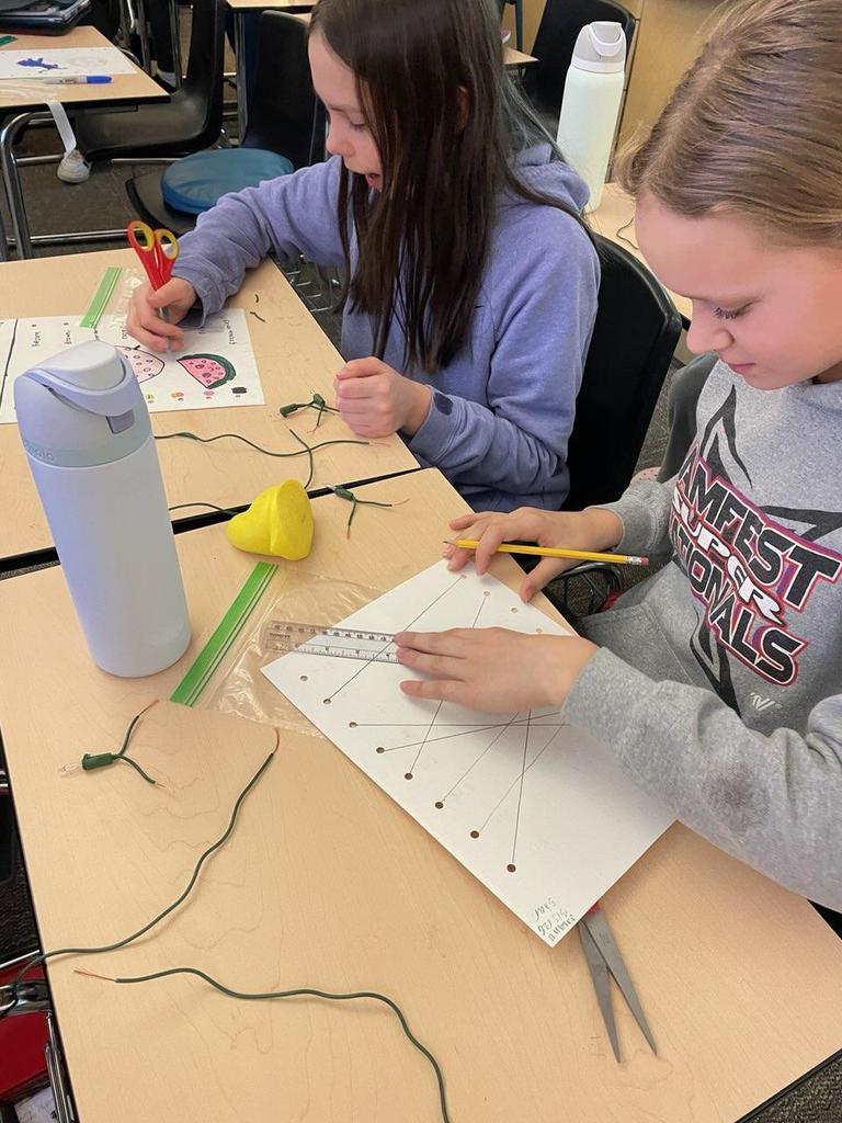 students at desk in classroom with STEM supplies