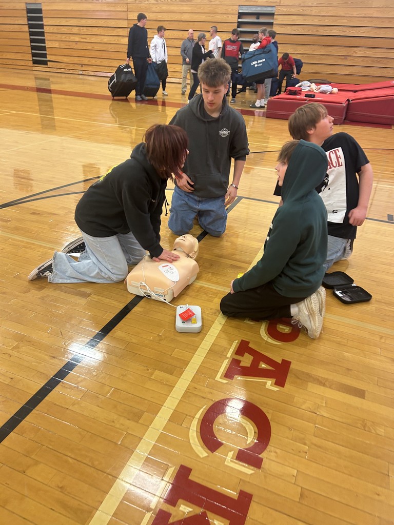Students performing CPR on dummy