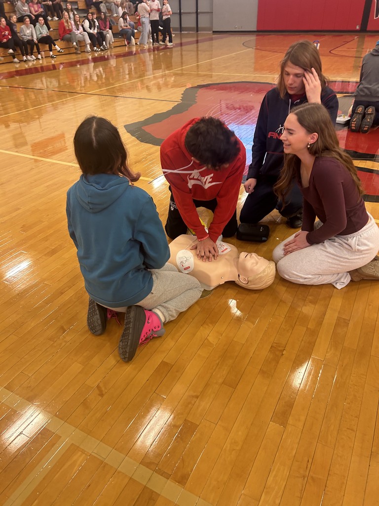 Students performing CPR on dummy
