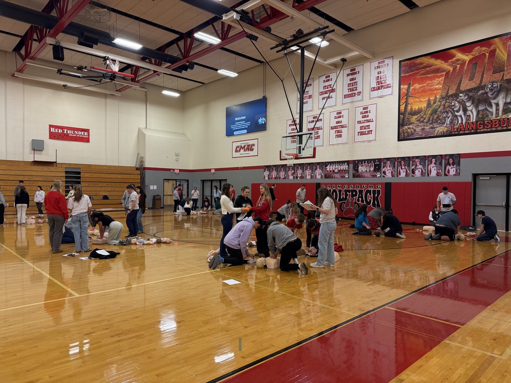 Students performing CPR on dummy