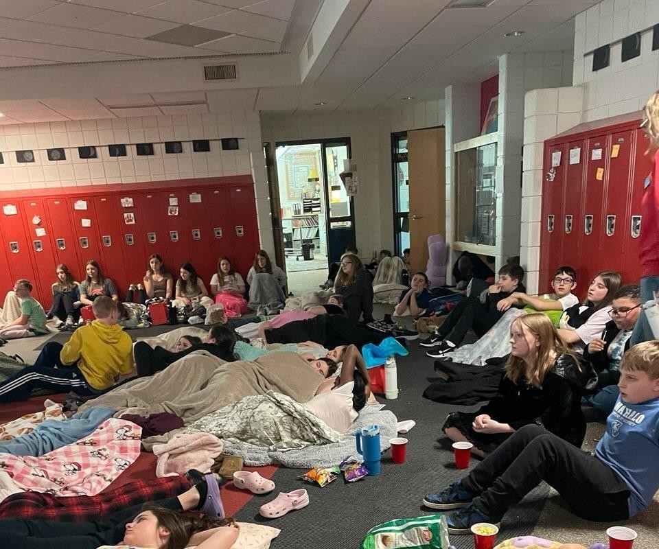 students resting on the floor with pillows and blankets