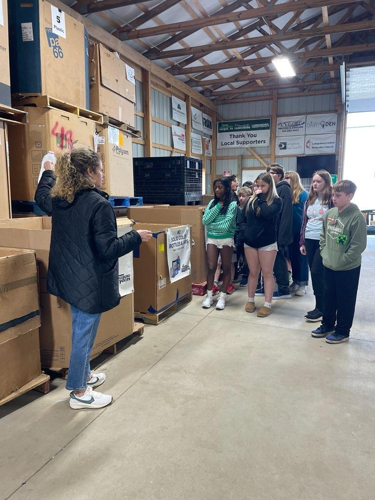 Students listening to speaker at recycling center