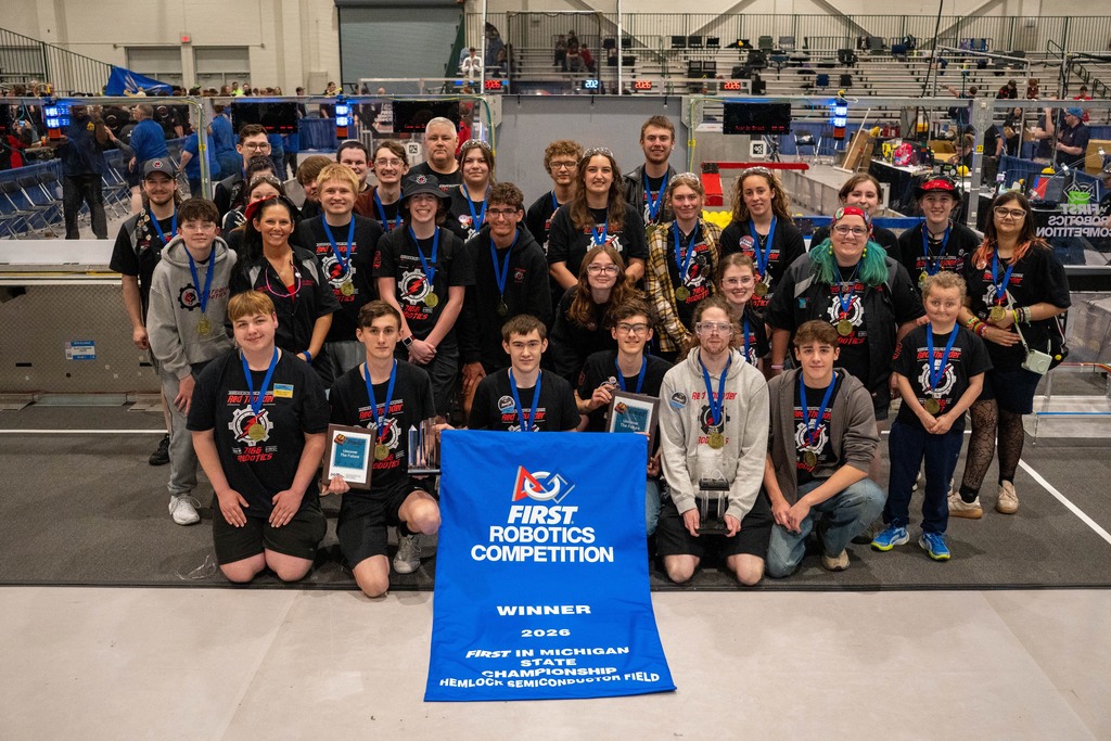 Robotics team holding championship banner at states