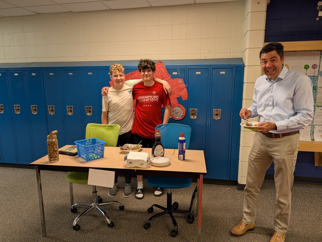 Kids behind a table in a school selling food  for their school project