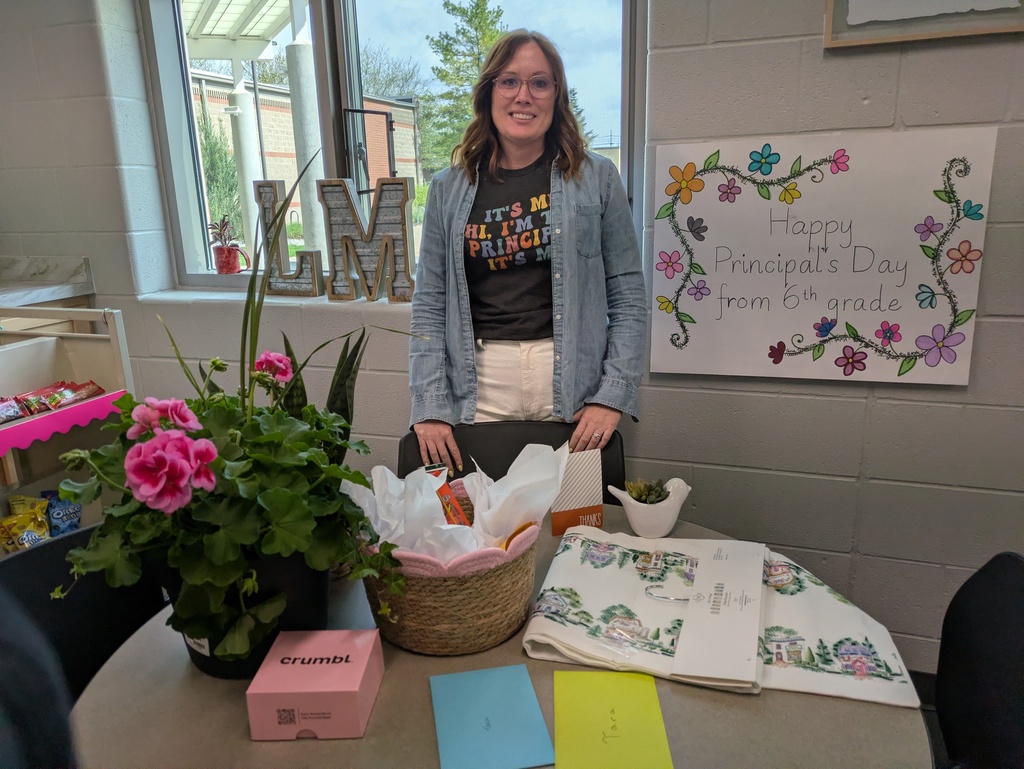 Principal standing behind table full of gifts