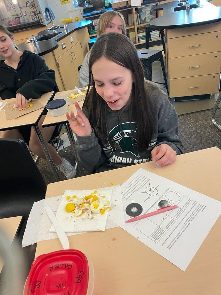 Student inspecting hard boiled egg
