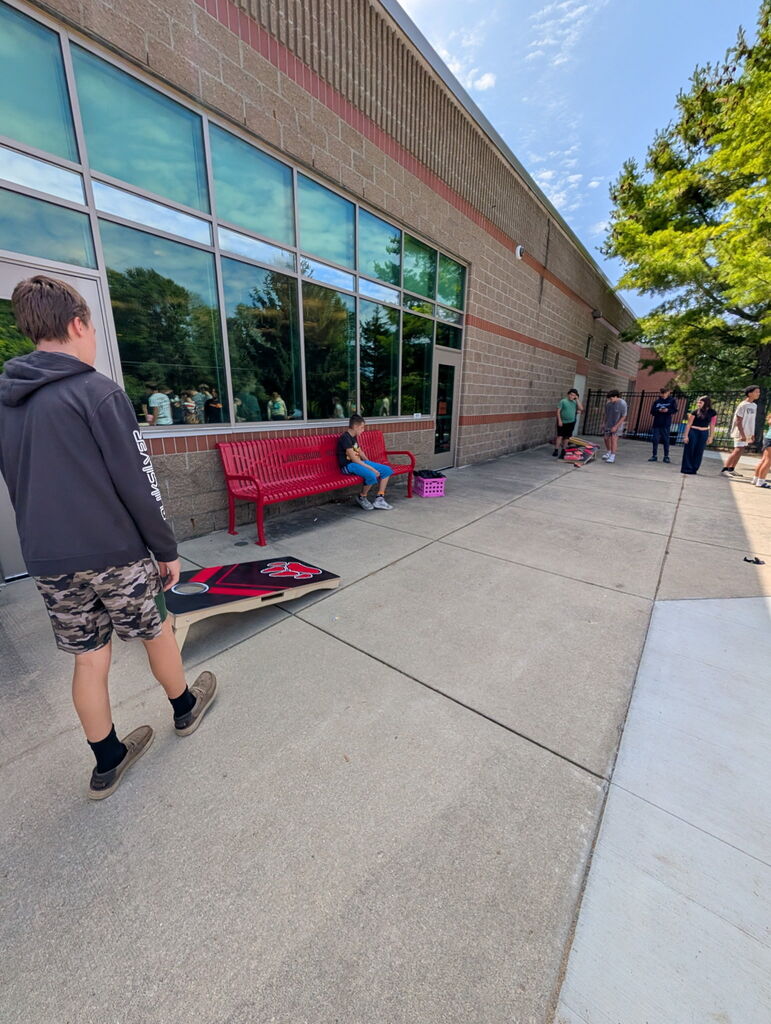 Students playing cornhole outside