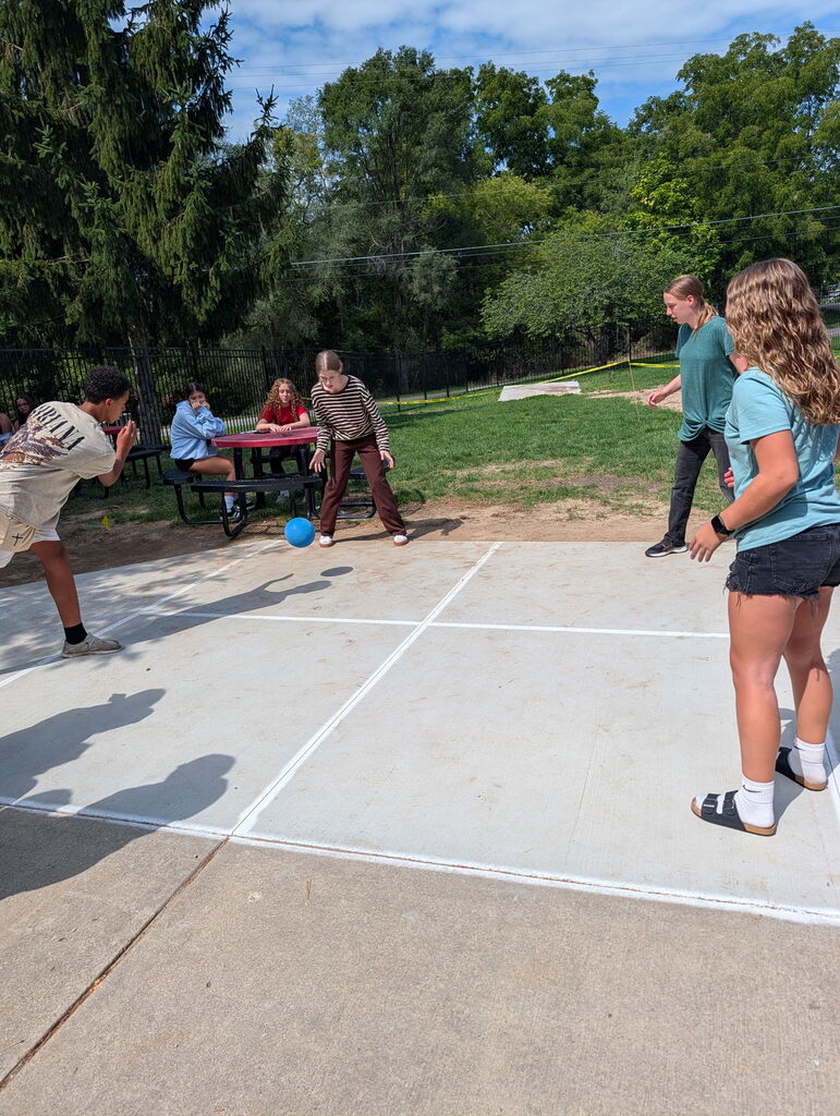 Students playing four square