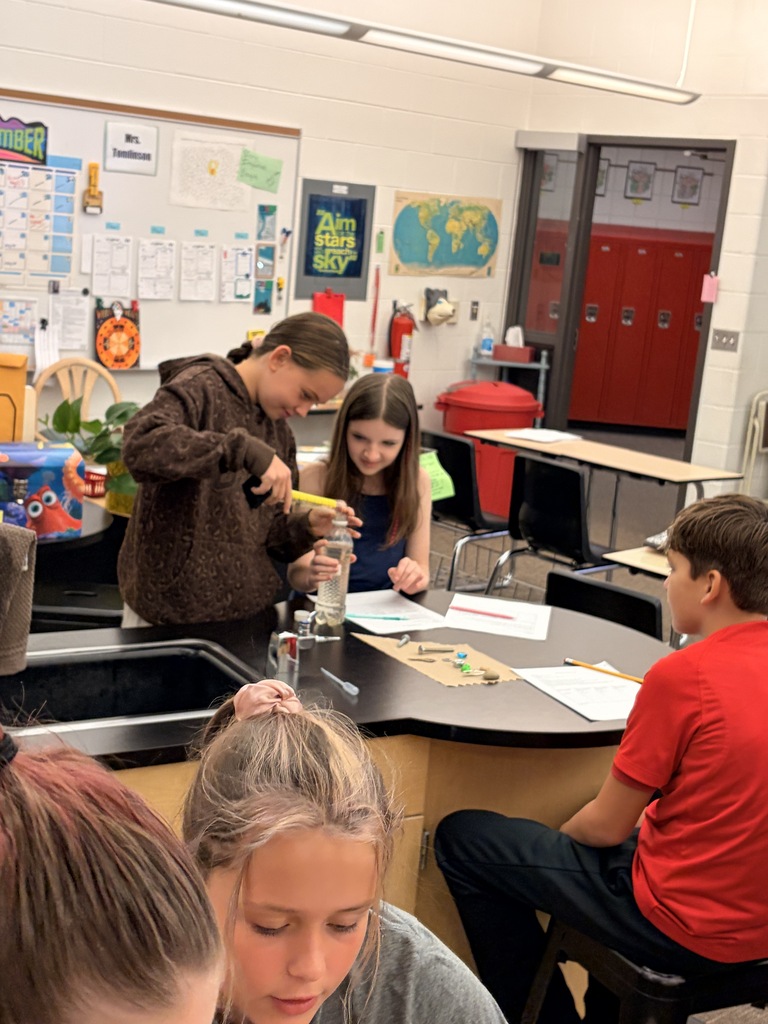 Students measuring fluid in science lab