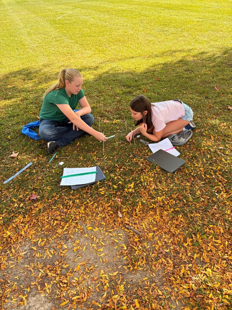 Students surveying the ground in STEM class