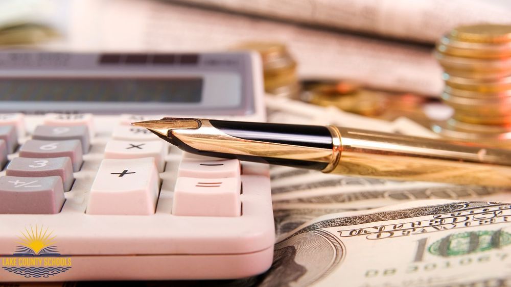 Calculator, cash and a gold pen
