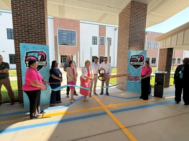 District and school officials cut blue ribbon in front  of new building at Beverly Shores Elementary