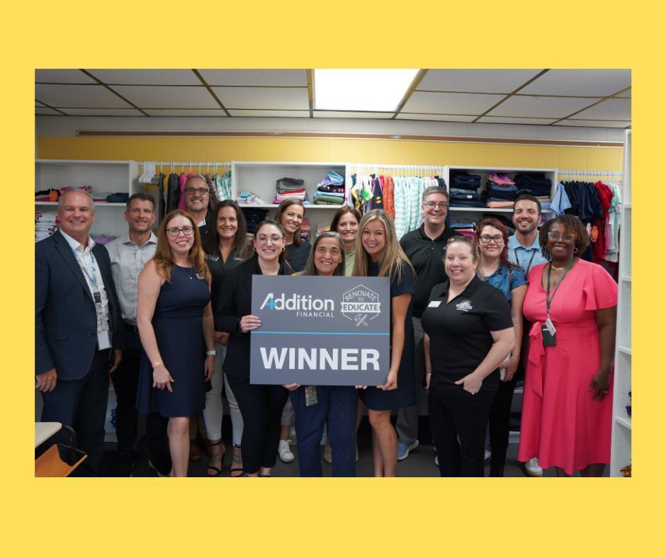 Group photo with sign that says Addition Financial Winner
