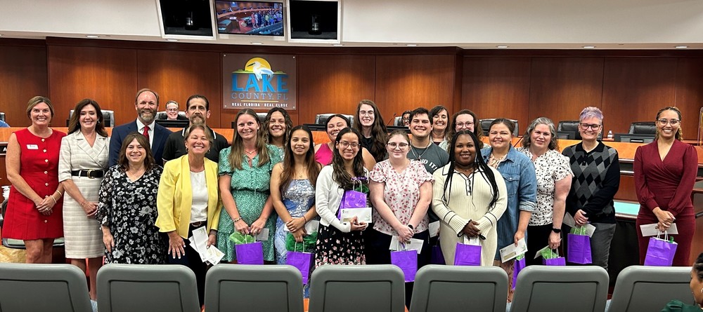 Group of adults posed with purple gift bags and gift envelopes
