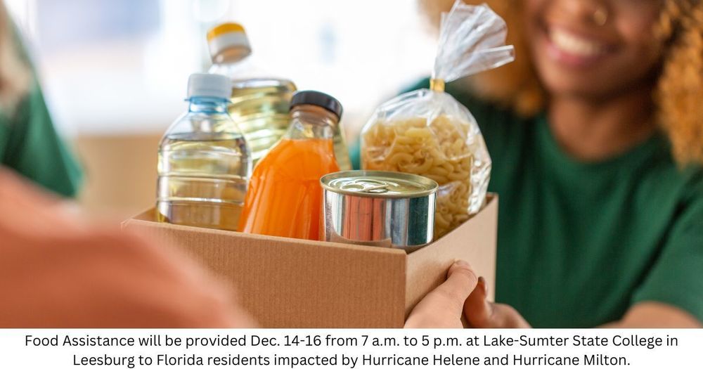 Woman handing a box of groceries to recipient