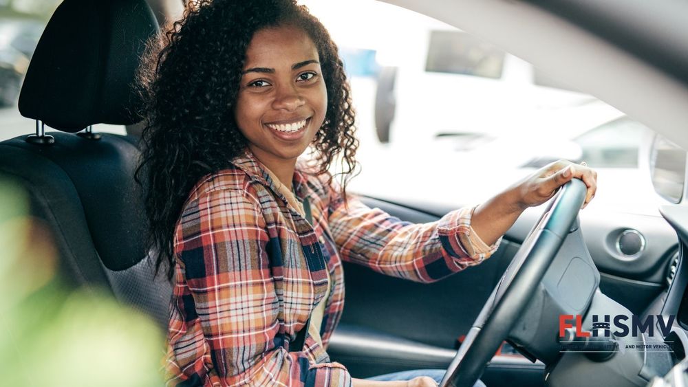 Teen girl behind the steering wheel of a car smiling at the camera. A logo for the Florida Highway Safety and Motor Vehicles Department is in the bottom right corner.