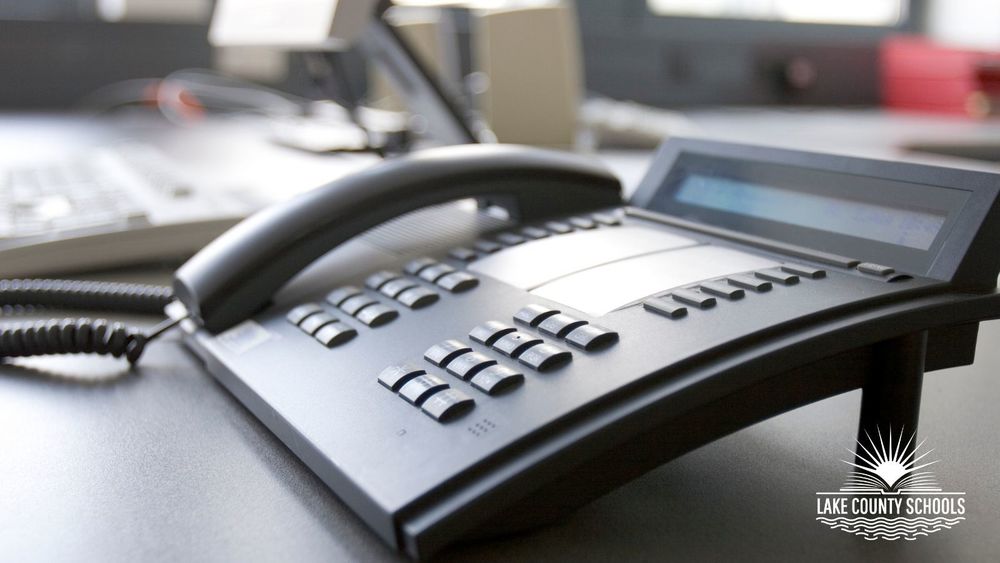 Black landline phone on an office desk