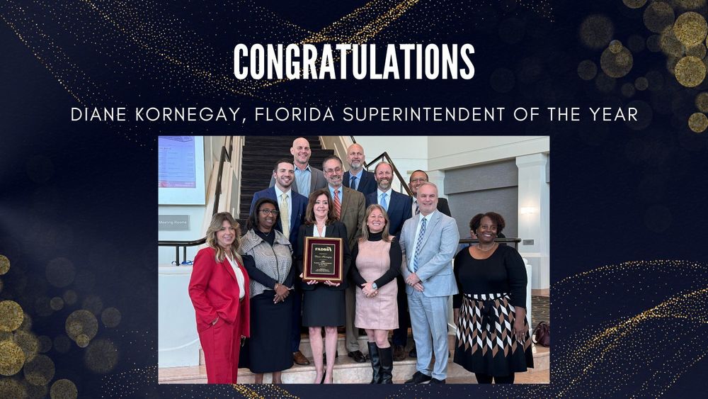 Diane Kornegay holding a plaque, surrounded by board members and senior staff