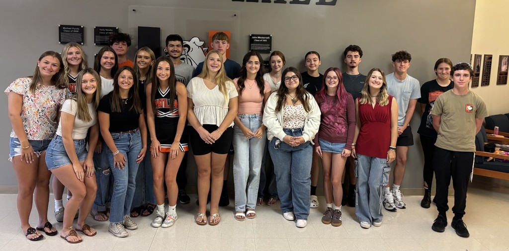 A group of Umatilla High School students stands together indoors, smiling for the camera. The students are celebrating their success on last year’s AICE Cambridge exams.