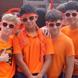 Photo of boys wearing orange shirts and orange sunglasses.