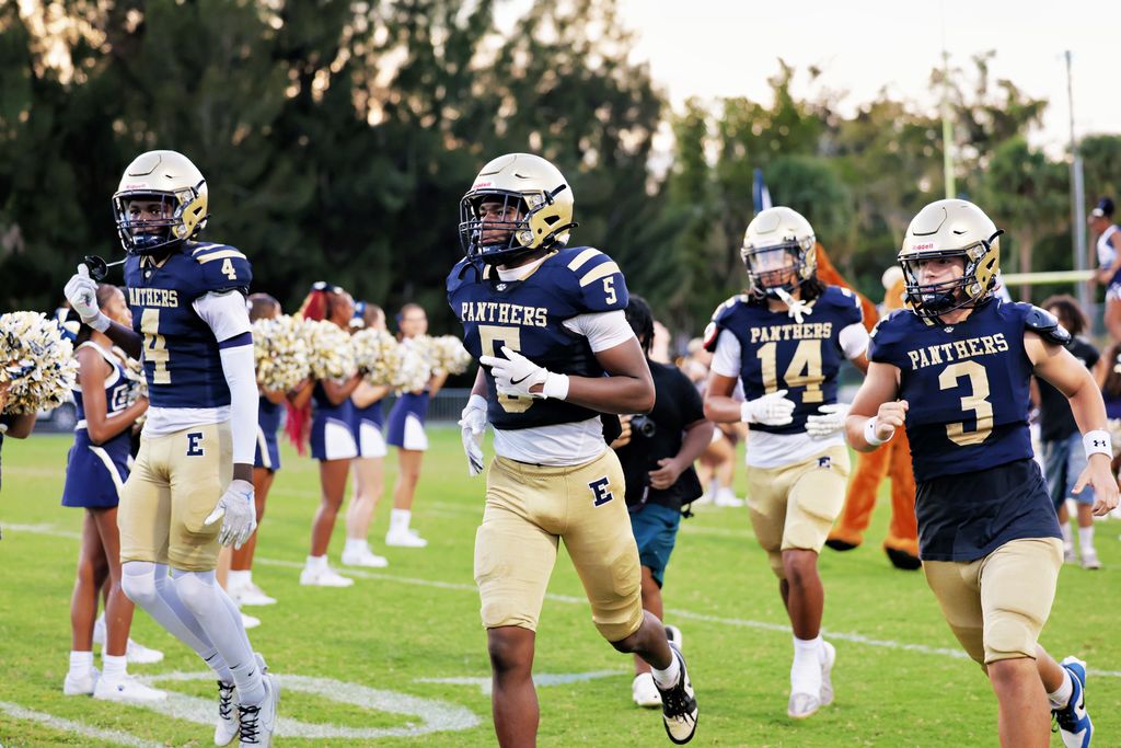 Football players running onto the field.