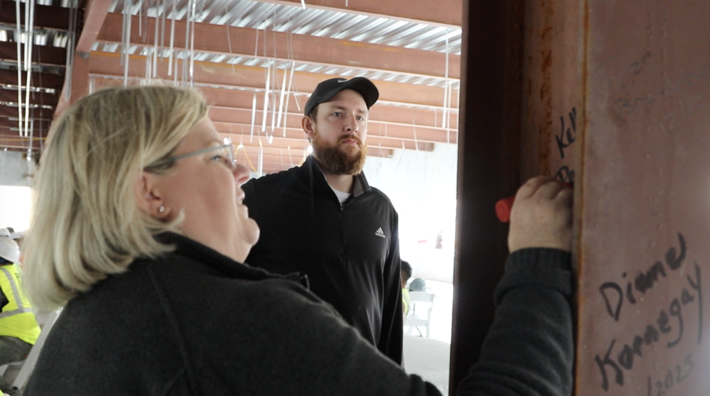 Kelly Randall signs a beam on the construction site of Beverly Shores Elementary School