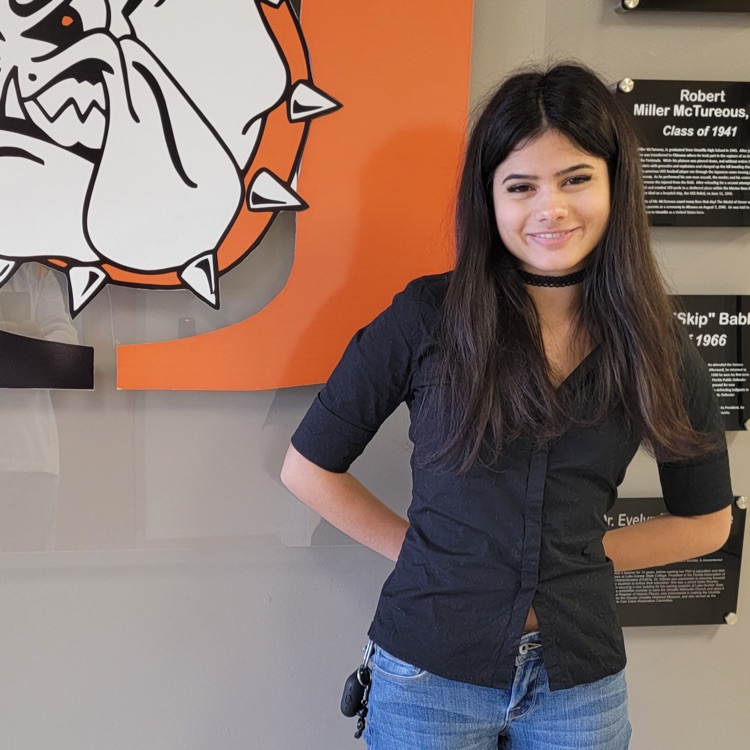 Karley Stewart poses in front of the Umatilla High logo. 