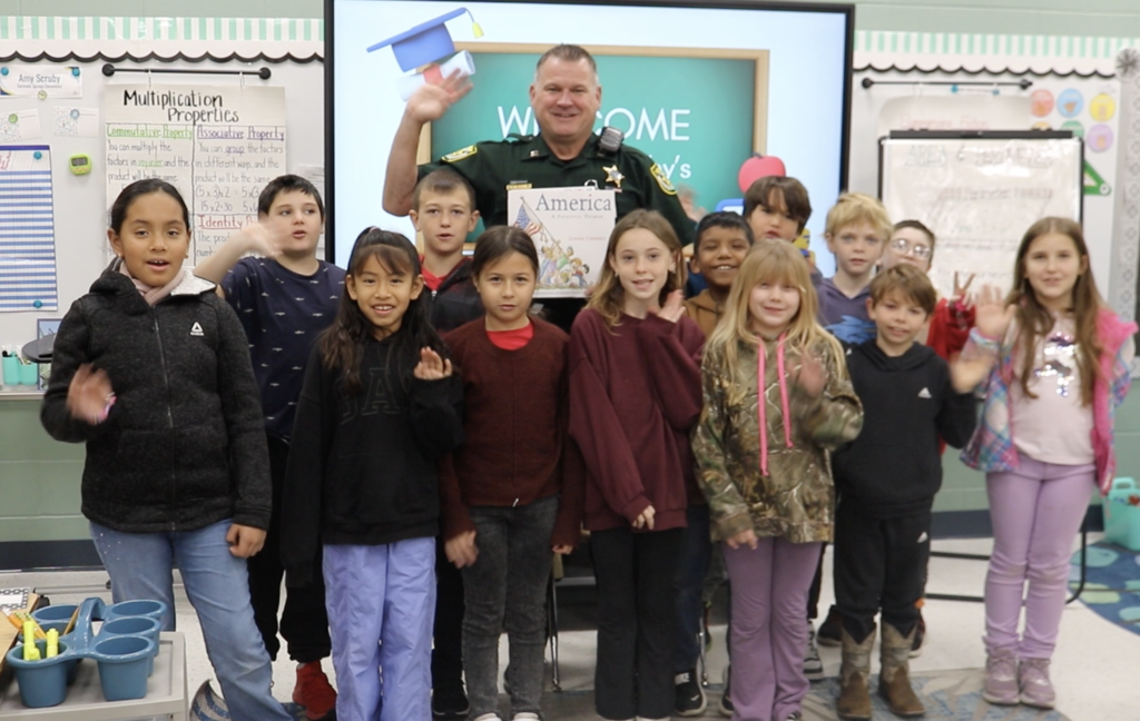 Students posed standing with deputy.