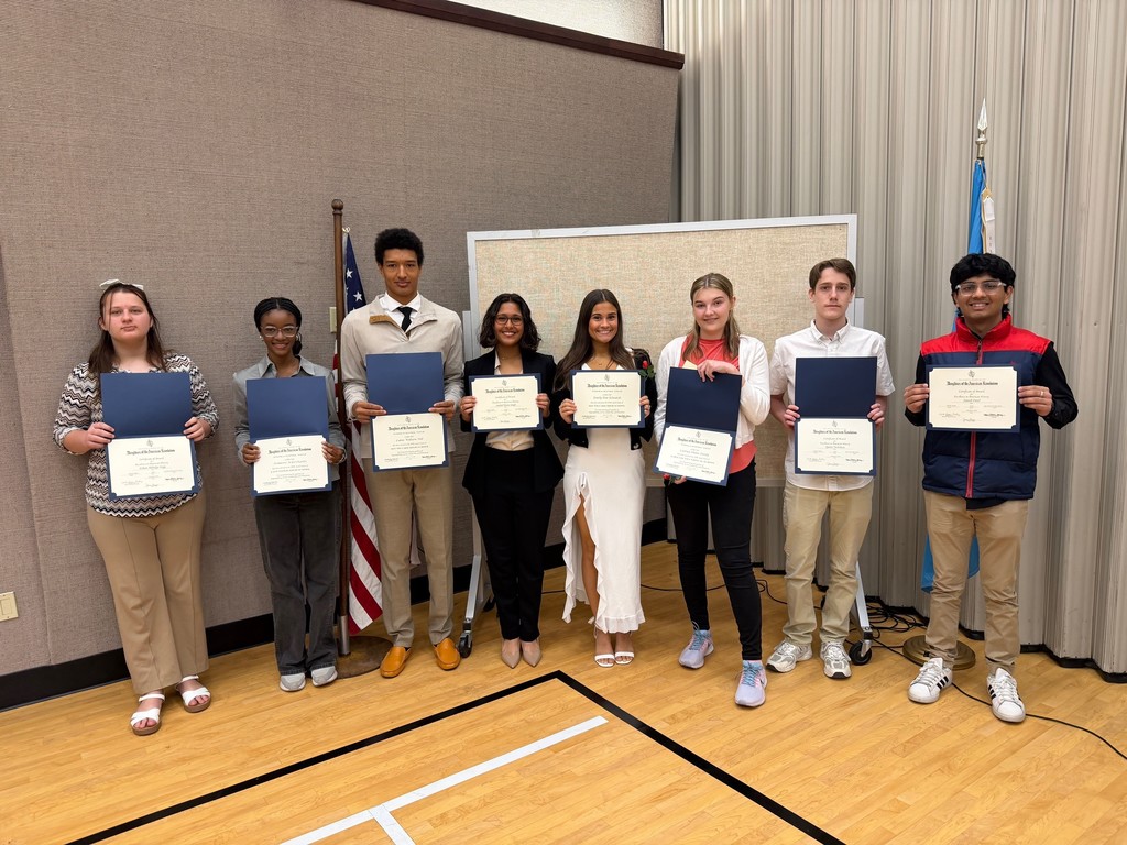 8 high school students posed, facing camera and holding certificates