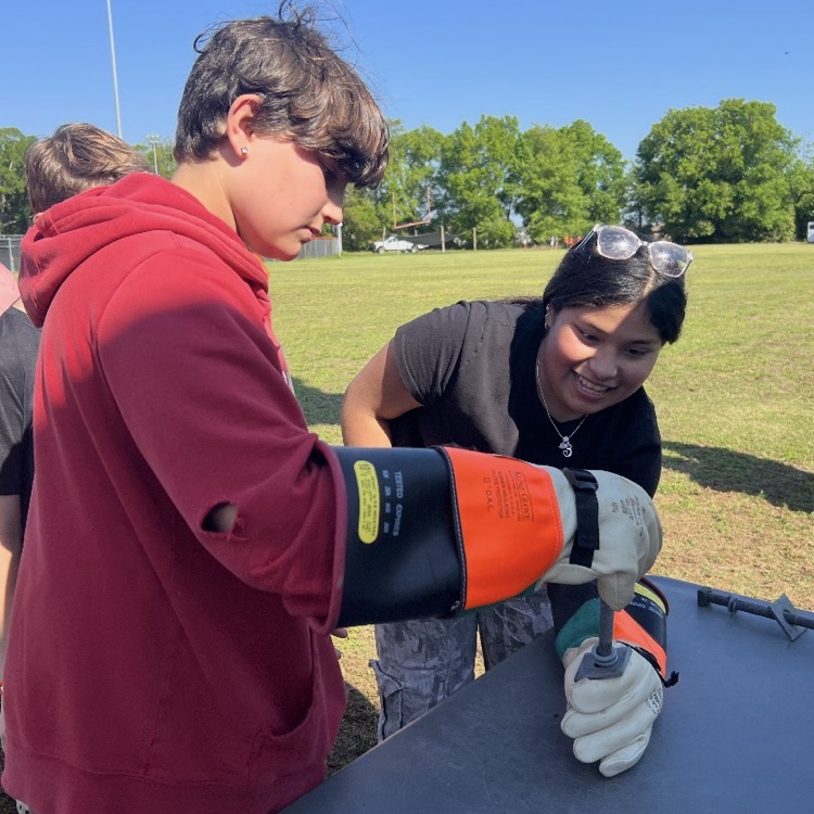 Duke Energy was showing students their safety gloves and how difficult it is to pick things up with them.